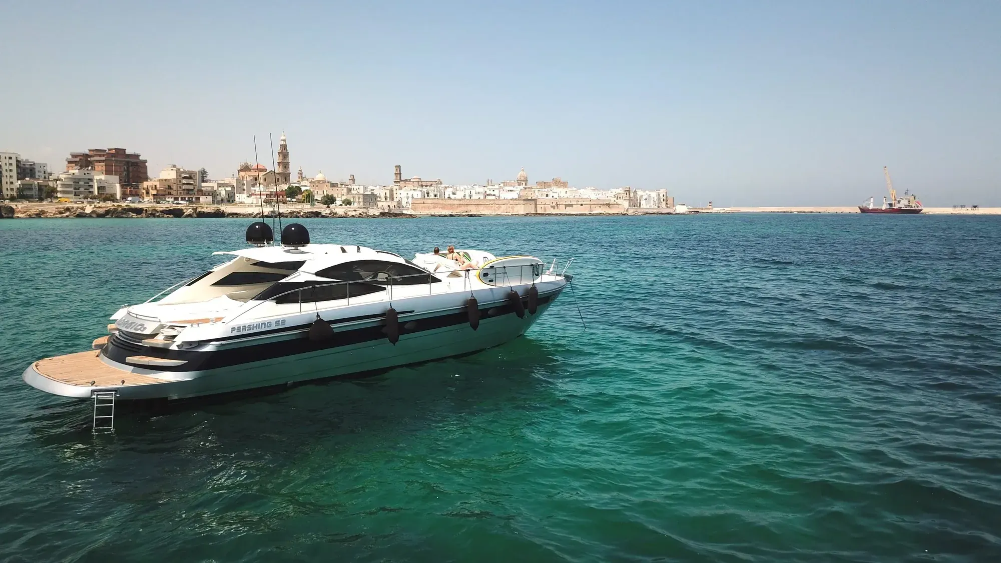 Motor yacht anchored near a Mediterranean coastal town